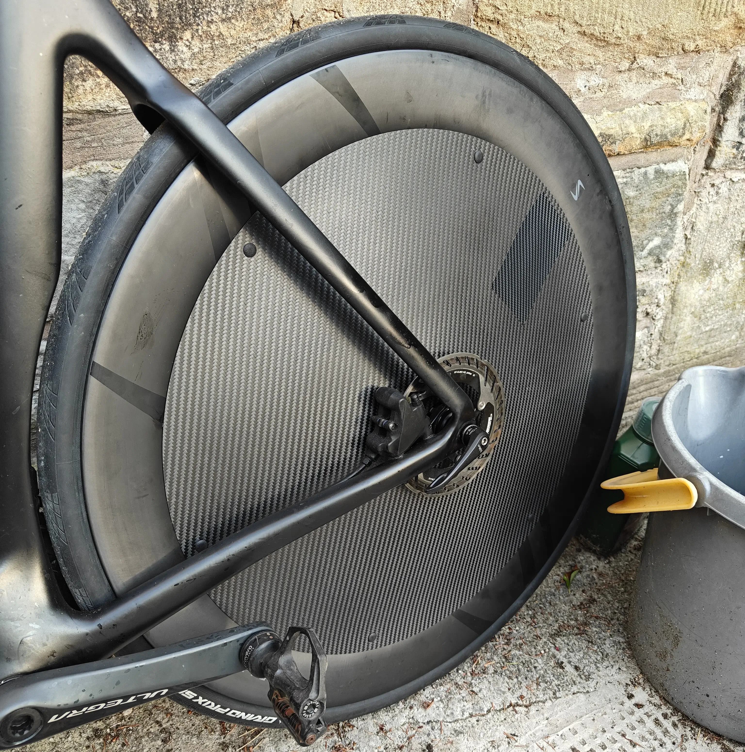 Close-up of carbon cycling wheel cover edge showing rubber rim protection lining.